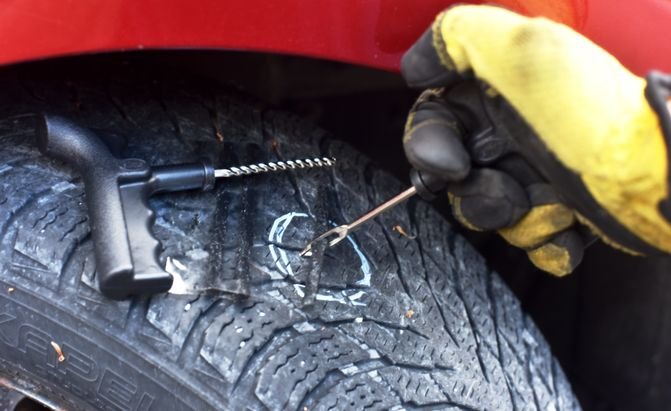 tire repair tools being used to fix a hole in a tire