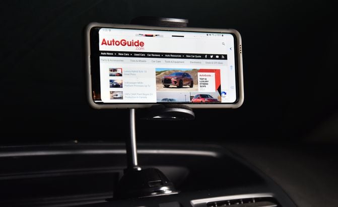 car phone mount on a Mazda5 dashboard showing the AutoGuide.com homepage