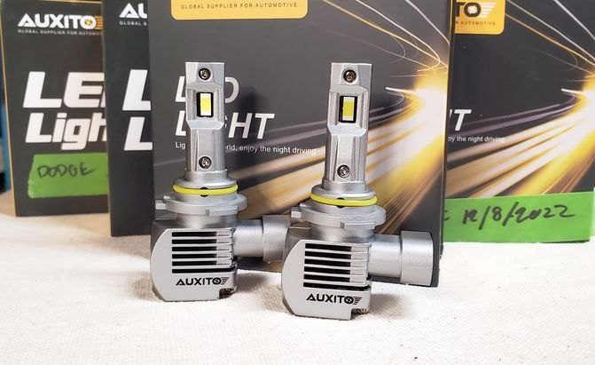 Two auxito led headlamp bulbs in front of their boxes