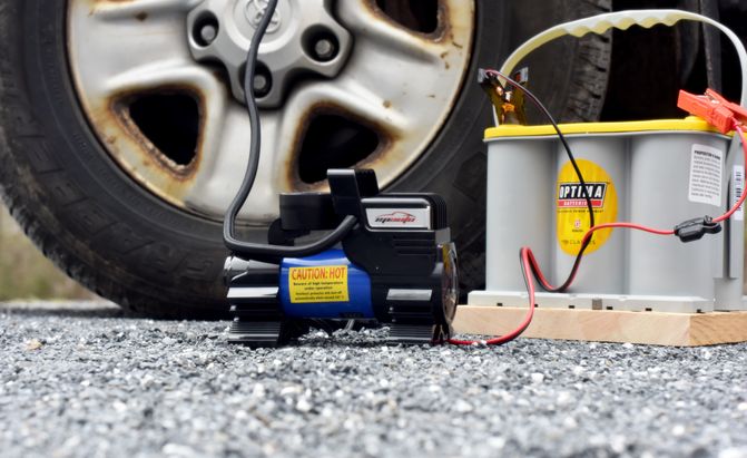 portable tire inflator connected to a battery
