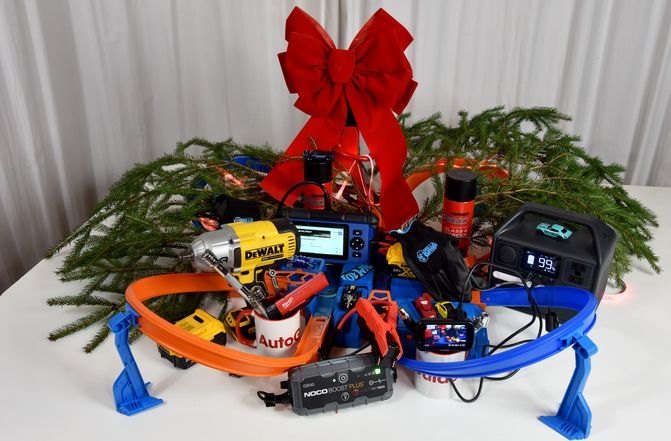 A pine bough wreath surrounding a pile of festive automotive tools and accessories