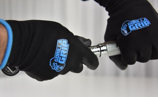 a pair of hands wearing gorilla grip work gloves, adjusting a 3/8 inch torque wrench